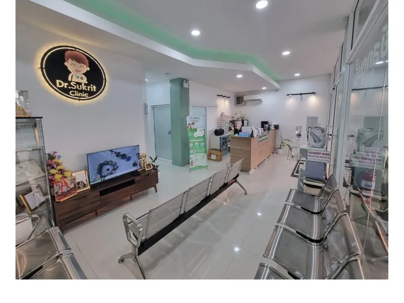 บริเวณนั่งรอภายในคลินิก มีป้ายไฟโลโก้ Dr.Sukrit Clinic